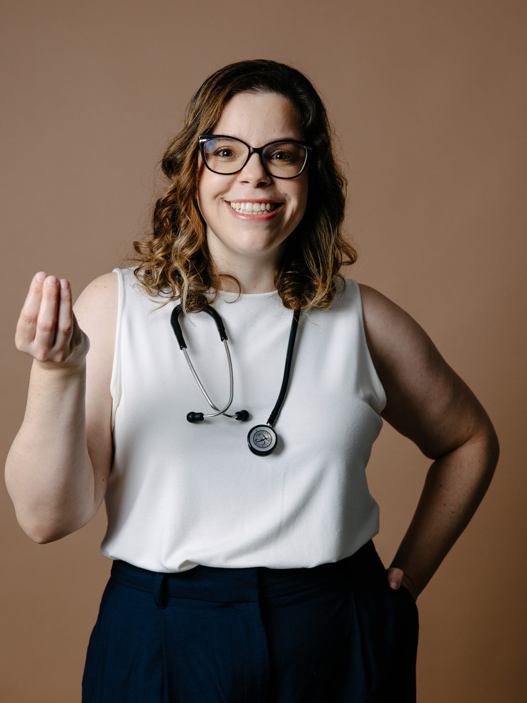 Dra. Clarissa Archanjo, pediatra, sorrindo, com estetoscópio no pescoço
